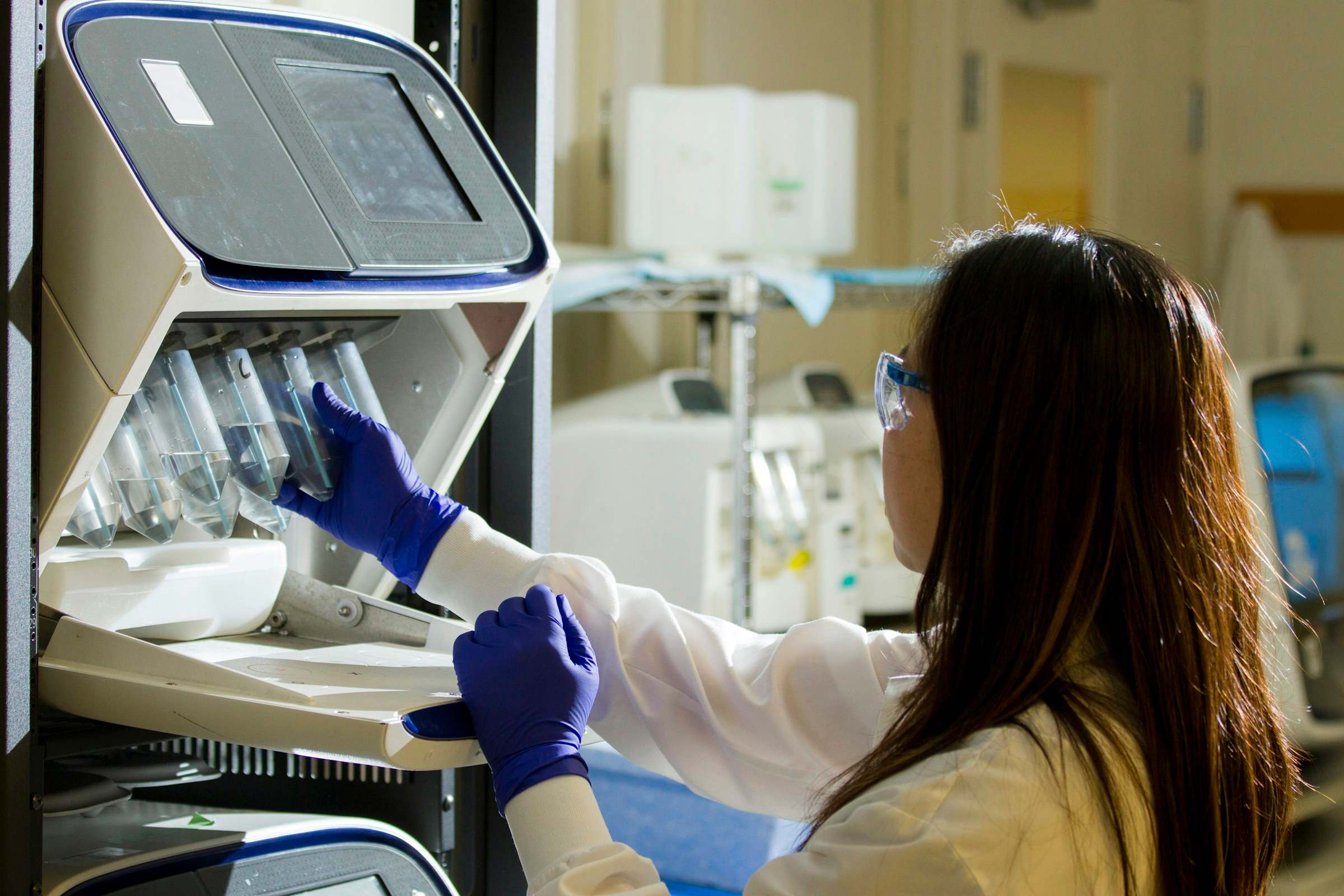 Técnica de laboratorio cargando tubos en un equipo de análisis molecular